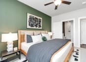 Thumbnail 17 of 37 - Apartment bedroom with ceiling fan and door open to a bathroom