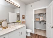 Thumbnail 28 of 37 - Bathroom with door open to a closet with shelves