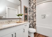 Thumbnail 34 of 37 - A bathroom with vanity cabinet, custom framed mirror, and soaking tub