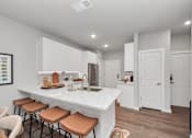 Thumbnail 10 of 18 - A kitchen with white cabinets and a marble countertop.