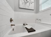 Thumbnail 16 of 18 - A white bathtub with a book on top of it.