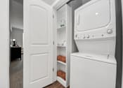 Thumbnail 17 of 18 - A white stackable washer and dryer in utility room