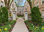 Thumbnail 1 of 23 - A pathway with a white fence and yellow flowers on the sides.