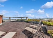 Thumbnail 40 of 43 - a rooftop patio with tables and chairs and a view of the city
