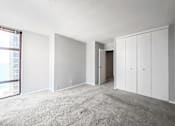 Thumbnail 25 of 36 - a bedroom with white walls and a concrete floor