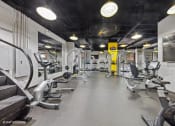 Thumbnail 45 of 62 - a gym with weights and cardio equipment on the floor and a wall mounted tv