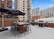 Thumbnail 4 of 45 - a patio with a table and chairs and a grill