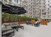 Thumbnail 5 of 45 - an outdoor lounge area with couches chairs and umbrellas