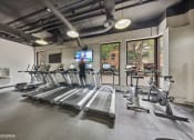 Thumbnail 47 of 62 - a gym with cardio equipment and windows in a building