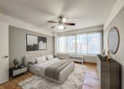 Thumbnail 7 of 27 - a bedroom with a large window and a ceiling fan