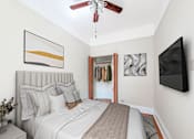 Thumbnail 6 of 38 - a bedroom with a large bed and a ceiling fan