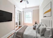Thumbnail 7 of 38 - a bedroom with a large bed and a ceiling fan