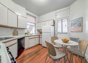 Thumbnail 3 of 38 - a kitchen with white cabinets and a white table and chairs