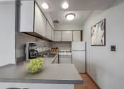 Thumbnail 12 of 37 - a kitchen with white cabinets and a bowl of green apples on the counter
