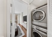 Thumbnail 23 of 62 - a laundry room with a washer and dryer and a door to a hallway