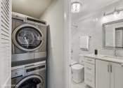 Thumbnail 16 of 62 - a bathroom with a washing machine and a toilet and a sink