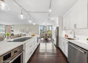 Thumbnail 8 of 62 - a large kitchen with white cabinets and stainless steel appliances