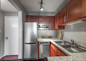 Thumbnail 44 of 53 - a kitchen with stainless steel appliances and wooden cabinets
