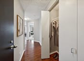 Thumbnail 39 of 53 - a hallway with a door to a closet with a jacket hanging on it