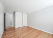 Thumbnail 23 of 28 - a bedroom with hardwood floors and white walls