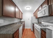Thumbnail 16 of 28 - a kitchen with granite countertops and wooden cabinets