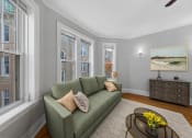 Thumbnail 5 of 24 - a living room with a green couch and three windows