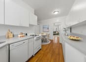 Thumbnail 8 of 24 - a white kitchen with white appliances and a dining room with a table