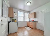 Thumbnail 7 of 31 - an empty kitchen with wooden floors and white appliances