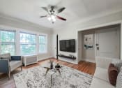 Thumbnail 4 of 31 - a living room with a ceiling fan and a tv