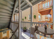 Thumbnail 12 of 31 - a covered porch with a table and chairs and a brick wall