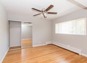 Thumbnail 17 of 28 - a bedroom with hardwood floors and a ceiling fan