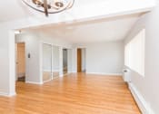 Thumbnail 16 of 28 - a living room with white walls and hardwood floors