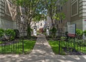 Thumbnail 24 of 24 - a sidewalk with a sign in front of an apartment building