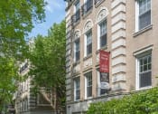 Thumbnail 23 of 24 - an apartment building with a black iron fence and a red sign on the side of the building