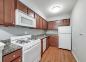 Thumbnail 6 of 28 - a kitchen with brown cabinets and white appliances