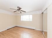 Thumbnail 23 of 28 - a bedroom with hardwood floors and a ceiling fan