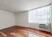 Thumbnail 12 of 43 - a bedroom with a large window and hardwood floors