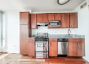 Thumbnail 11 of 43 - a kitchen with wooden cabinets and stainless steel appliances