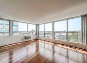 Thumbnail 8 of 43 - a bedroom with a large window and hardwood floors