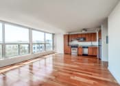 Thumbnail 10 of 43 - an empty living room and kitchen with wood floors and large windows
