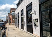 Thumbnail 28 of 29 - a white brick building with black windows and doors