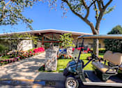 Thumbnail 38 of 51 - A golf cart is parked in front of a house with a sign that says "Welcome to Paradise.".