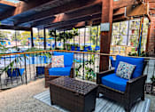 Thumbnail 39 of 51 - A patio with blue chairs and a wicker table.