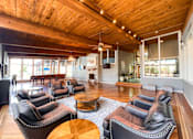 Thumbnail 49 of 51 - A living room with leather chairs and a wooden ceiling.