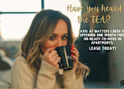 Thumbnail 2 of 29 - A woman holding a coffee mug with text about a free month lease offer from Axis at Watters Creek.