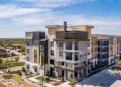 Thumbnail 5 of 29 - an aerial view of a large apartment complex with cars parked on the side of the road