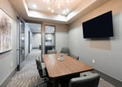 Thumbnail 24 of 29 - a meeting room with a table and chairs and a tv on the wall