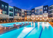 Thumbnail 3 of 29 - a swimming pool with chaise lounge chairs in front of a building