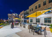 Thumbnail 9 of 29 - a patio with yellow umbrellas at night