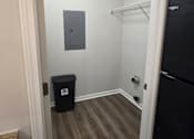 Thumbnail 36 of 49 - A small room with a black fridge and a black bin.